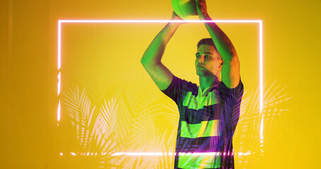Caucasian rugby player throwing ball by illuminated rectangle and plants over yellow background