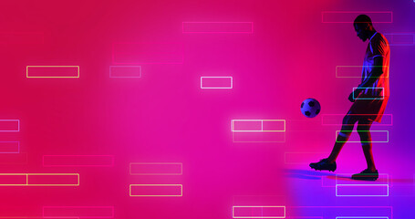 Side view of african american male player playing with soccer ball by illuminated rectangles