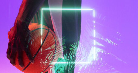 Multiple exposure of african american basketball player holding ball over plants with square neon