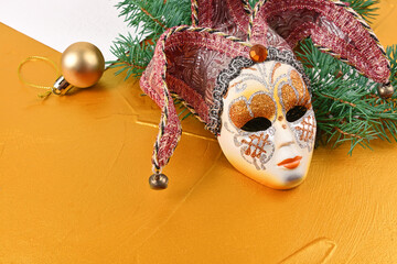Christmas venetian mask on gold background close up view
