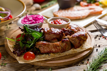 Kebab of pork with red onion and tomato sauce on wooden table macro close up