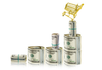 Banknoty dolarowe przypominające wykres inflacji. Na szczycie stoi złoty koszyk sklepowy, wskazujący na wzrost cen. - obrazy, fototapety, plakaty