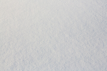 Natural snow texture. Smooth surface of clean fresh snow. Snowy ground. Winter background with snow patterns. Perfect for Christmas and New Year design. Closeup top view.