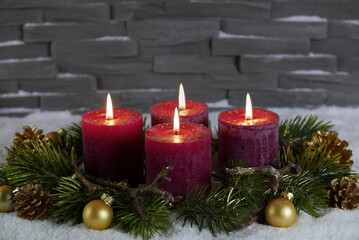Fototapeta na wymiar Adventskranz mit vier brennenden roten Kerzen zum vierten Advent.