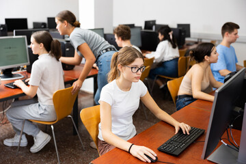 Fototapeta premium Portrait of interested teen girl during lesson in computer room of school computer class