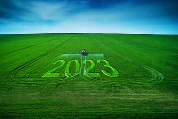 Fototapete Rund 2023 Happy New Year concept and Aerial view of farming tractor plowing and spraying on field. © ValentinValkov