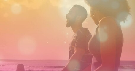 Animation of light spots over african american couple walking at beach - Powered by Adobe