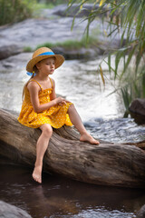 girl in a hat sitting by the river