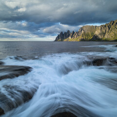 Fototapeta na wymiar Waves flow over rocky shoreline at Tungeneset viewpoint, Senja, Norway