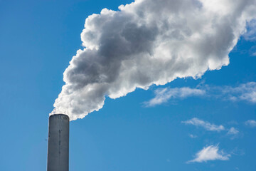 Industrial chimney, thermal power plant, pollution in the air, steam cooling tower in Graz, Styria region, Austria.