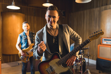 Fototapeta premium Man poses with an electric guitar during a music band performance . High quality photo