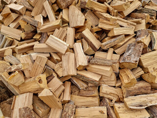 Chopped down tree trunks, firewood stacked in a storage yard, for heating in winter. Selective focus