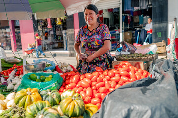 Retrato de mujer indigena viendo a Camara en su puesto de frutas y verduras en un mercado local. 