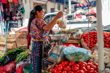 Vendedora indígena en un puesto de verduras frescas. 