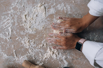 Fototapeta premium Young housewife in an apron kneads dough with her hands.