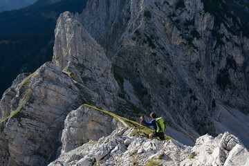 Mountaineer  on rocky ridge, evening light in wild terrain - obrazy, fototapety, plakaty