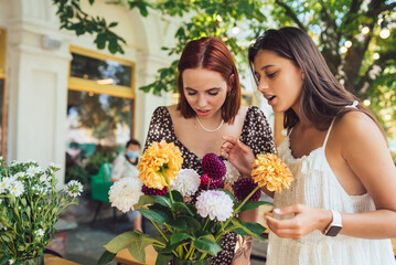 Two young women make up a beautiful festive bouquet.