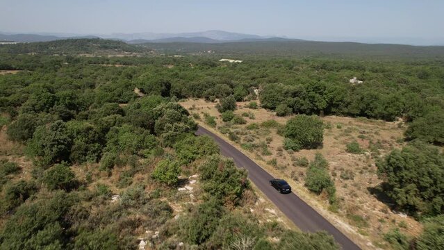 Black electric car driving countryside south of France sunny day 