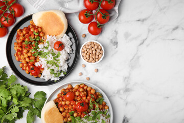 Delicious chickpea curry with rice served on white marble table, flat lay. Space for text
