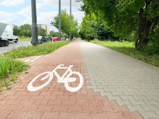 Street with road, pedestrian zone and red paved bicycle lane - obrazy, fototapety, plakaty