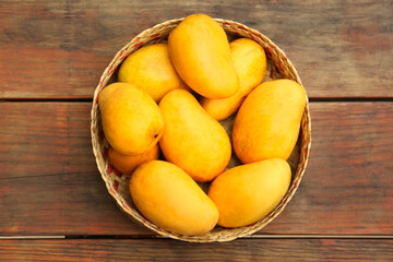 Naklejka na ściany i meble Delicious ripe juicy mangos on wooden table, top view
