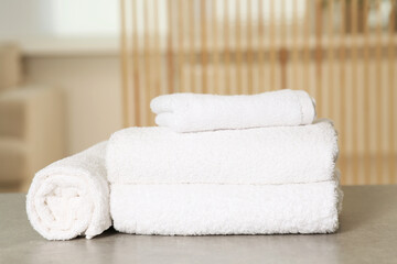Fototapeta na wymiar Soft folded terry towels on light gray table indoors