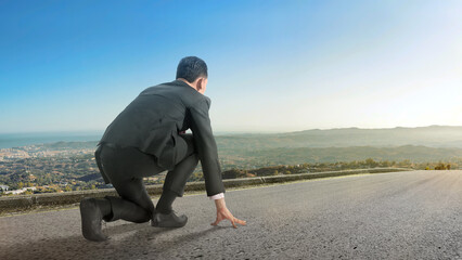 Rear view of Asian businessman in start position ready to run