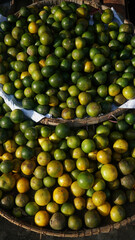 Lime or kaffir lime on a bamboo basket in a traditional market. Focus selected