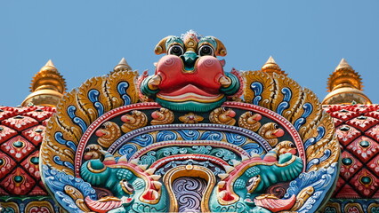 Minor demon adorns the top of colorful Hindu temple