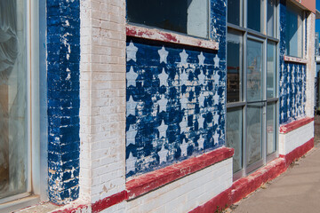 Weathered building front painted in colors, stars and stripes of the American flag - Powered by Adobe