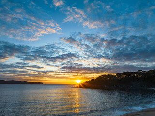 Aerial sunrise seascape with calm seas and a mix of low and medium clouds