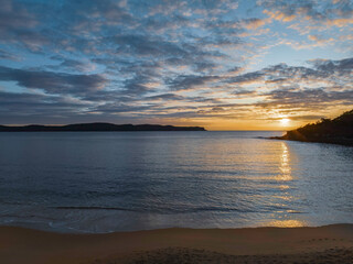 Aerial sunrise seascape with calm seas and a mix of low and medium clouds
