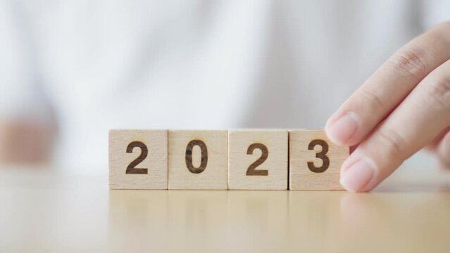 New year 2022 change to 2023. Hand putting wooden cube block with year number. New year resolution, Merry Christmas