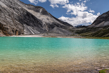Milk lake in Yading Nature reserve. Daocheng Yading Natural Reserve Scenic Area consists of three holy snow mountains, namely Xiannairi, Jiangbianyang and Xianaduoji, and surrounding rivers, lakes