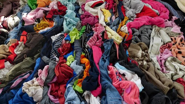 Used clothes. A big pile of old unnecessary clothes. Fast fashion, garbage and pollution