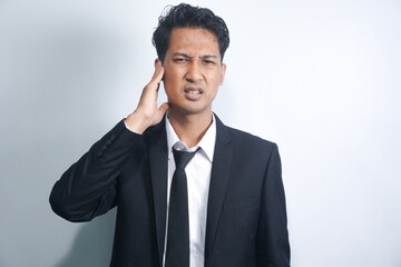 Unhealthy young asian man suffering from sudden throbbing ear ache.