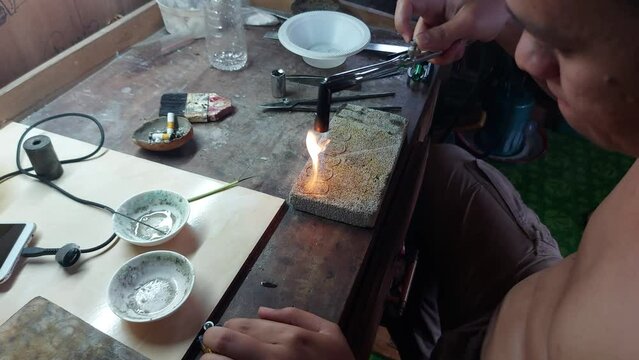 Goldsmith working on his workbench. Production and making process precious gold jewelry, jewels, ring jeweler, goldsmith in workshop.