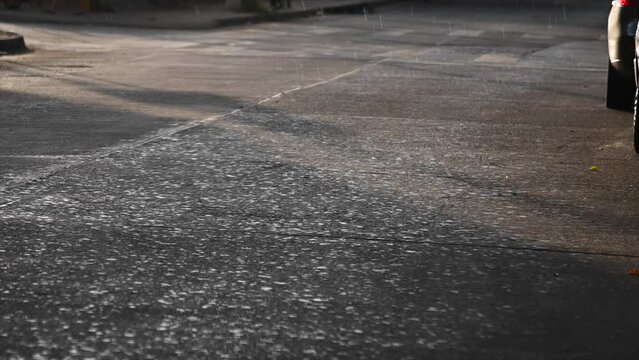 rain with sun on pavement in slow motion Cordoba argentina