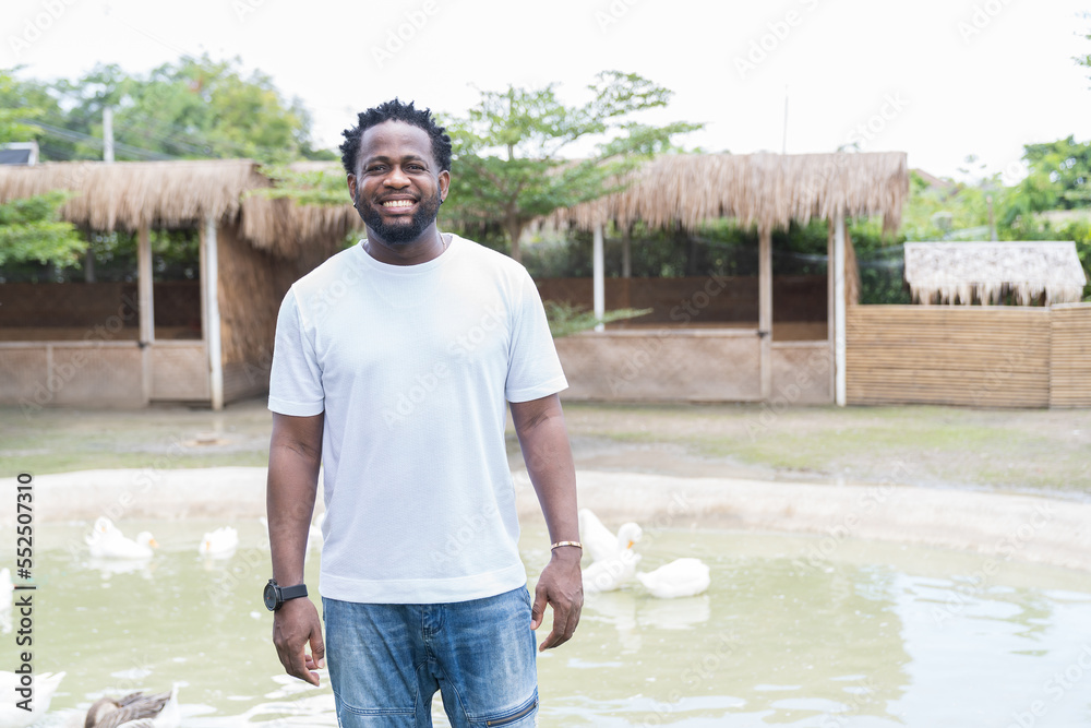 Wall mural Happy African American man travel in the animal farm. Holiday and travel concept