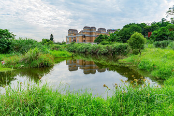 Fototapeta na wymiar Sunny view of a pond landscape with a residence building in Xindian District