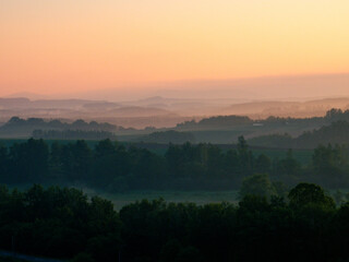 Spring hills where the dawn breaks through the morning fog