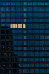 Fototapeta na wymiar Working late at night overtime, office building with one set of windows glowing