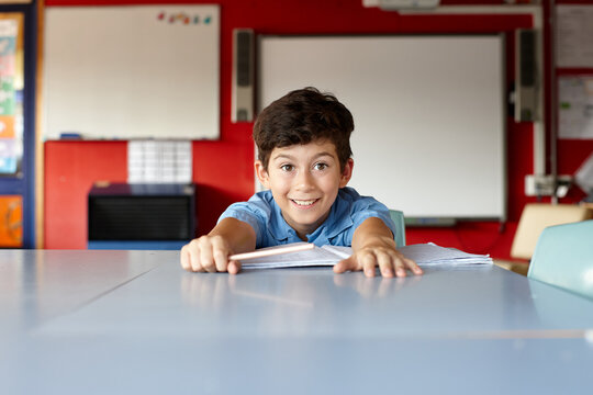Happy young school boy in classroom