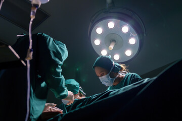 Fototapeta na wymiar A team of professional doctors perform surgery in a hospital, a group of surgeons working in the operating theater.