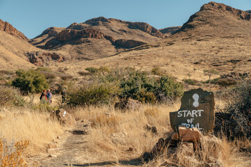 Familie wandert in der Morgensonne über den Olive Trail, einen Pfad im Naukluft Gebirge, Namibia - obrazy, fototapety, plakaty