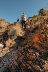 Familie wandert in der Morgensonne über den Olive Trail, einen Pfad im Naukluft Gebirge, Namibia
