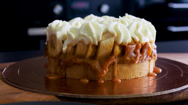Banoffi cake made of shortbread, bananas and homemade caramel, cake with bananas, caramel and cream , cut a piece