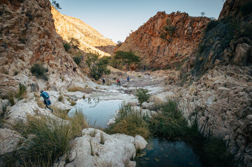 Familie trifft während einer Wanderung über den Olive Trail, ein Pfad im Naukluft Gebirge, auf einen Felsenpool , Namibia
