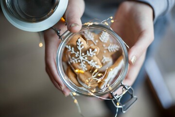 a retro glas jar with christmas gingerbread in girl hands sweet gift in christmas mood