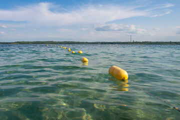 Yellow buoy line floating on the tranquil water. Zone of safety swimming